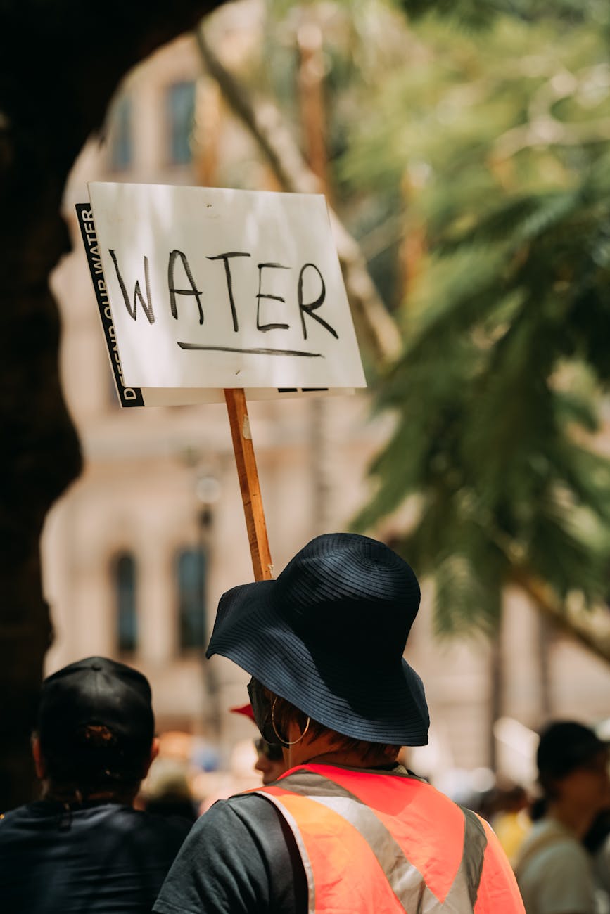 person in hat and with banner with water text